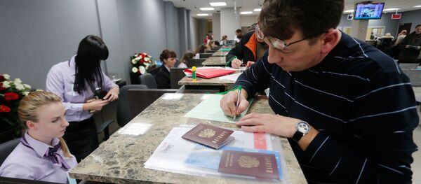 A visitor files papers at Visa Application Center A visitor files papers at Visa Application Center - Sputnik International