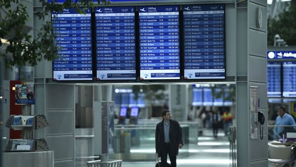 A passengers walks under information boards at the airport in Duesseldorf, Germany - Sputnik International