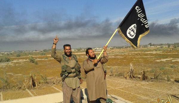 Islamic State militant waves his group's flag as he and another celebrate in Fallujah, Iraq, west of Baghdad Islamic State militant waves his group's flag as he and another celebrate in Fallujah, Iraq, west of Baghdad - Sputnik International