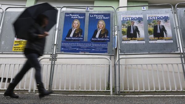 A woman walks past electoral posters of far right National Front party regional leader for southern France, Marion Marechal-Le Pen, left, and French right-wing party Les Republicains candidate Christian Estrosi, in Nice, southeastern France, Saturday, Dec. 5, 2015. - Sputnik International