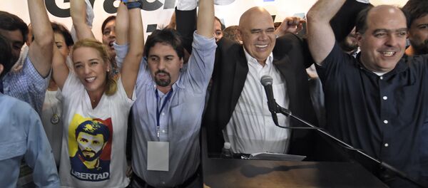 (L to R) The wife of jailed Venezuelan opposition leader Leopoldo Lopez, Lilian Tintori (C) Freddy Guevara, of the Voluntad Popular party, Jesus Torrealba, head of the Democratic Unity Movement (MUD) party and deputy Julio Borges celebrate after knowing the first results of the legislative election, at the MUD headquarters in Caracas, on the early morning December 7, 2015. - Sputnik International