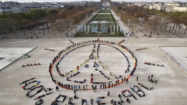 Environmentalist activists form a human chain representing the peace sign and the spelling out 100% renewable, on the side line of the COP21, United Nations Climate Change Conference near the Eiffel Tower in Paris, Sunday, Dec. 6, 2015. - Sputnik International