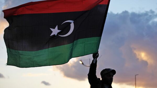 A Libyan waves the national flag - Sputnik International