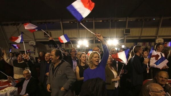 Supporters of far right National Front party regional leader for southeastern France, Marion Marechal-Le Pen, wave flags at a meeting after the results of the first round of the regional elections, in Carpentras, southern France - Sputnik International