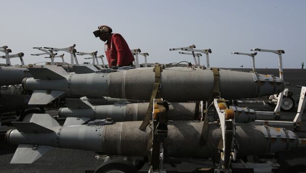 A US sailor works with bombs being prepared for loading on military jets on the flight deck of the USS Carl Vinson aircraft carrier in the Persian Gulf. File photo. - Sputnik International