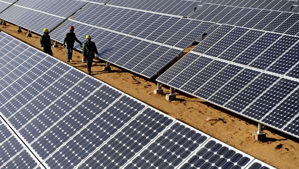 Workers check solar panels in Yulin, northwest China's Shaanxi Province, as the traditional mineral-resource-rich city turned its development on clean energy industries such as wind power or solar power - Sputnik International