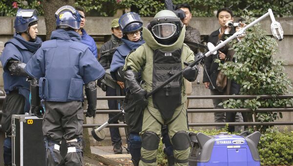 Members of a police bomb disposal squad wearing blast protection equipments prepare to work near the site of an explosion at the Yasukuni shrine in Tokyo, in this photo taken by Kyodo November 23, 2015 - Sputnik International