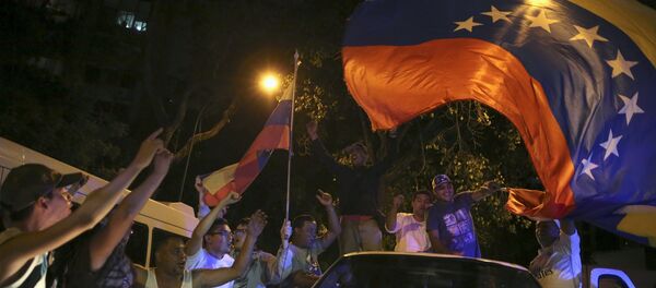 Supporters of the opposition Democratic Unity coalition wave a Venezuelan national flag from a car while they celebrate their victory on a street in Caracas December 7, 2015 Supporters of the opposition Democratic Unity coalition wave a Venezuelan national flag from a car while they celebrate their victory on a street in Caracas December 7, 2015 - Sputnik International
