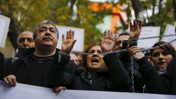 Demonstrators raise their chained hands during a protest over the arrest of journalists Can Dundar and Erdem Gul in Ankara, Turkey, November 27, 2015 - Sputnik International