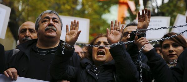 Demonstrators raise their chained hands during a protest over the arrest of journalists Can Dundar and Erdem Gul in Ankara, Turkey, November 27, 2015 - Sputnik International