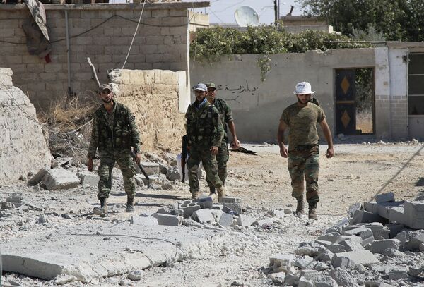  Syrian army soldiers walk in Achan, Hama province, Syria  - Sputnik International