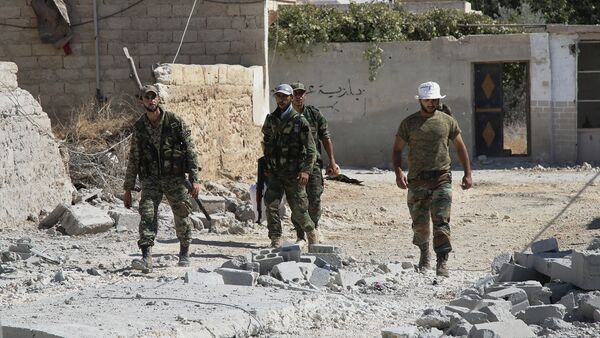 Syrian army soldiers walk in Achan, Hama province, Syria - Sputnik International