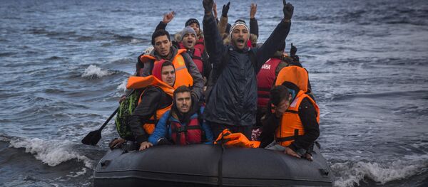 Migrants and refugees react as they arrive on a dinghy from the Turkish coast to the northeastern Greek island of Lesbos on Wednesday, Dec. 9, 2015. - Sputnik International
