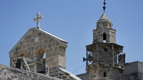 The bell tower of St. Porphyrios Greek Orthodox church, left, and the minaret of the adjacent Kateb Welaya mosque, right, are seen in Gaza City, Sunday, Aug. 10, 2014 - Sputnik International