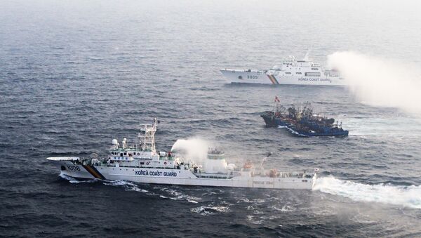 A picture taken on December 21 from a South Korean helicopter shows 12 Chinese fishing boats (C) banded together with ropes to thwart an attempt by South Korean coastguard ships to stop their alleged illegal fishing in the Yellow Sea off the coast of South Korea - Sputnik International