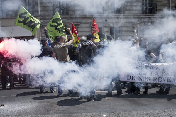 Striking workers of the French state-run rail operator SNCF, backed by French unions CGT and Sud-Rail, protest with flares during a demonstration against reform plans proposed by the French government, on June 18, 2014, at the Austerlitz train station in Paris Striking workers of the French state-run rail operator SNCF, backed by French unions CGT and Sud-Rail, protest with flares during a demonstration against reform plans proposed by the French government, on June 18, 2014, at the Austerlitz train station in Paris - Sputnik International