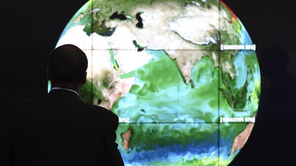 A conference attendee looks at a projection of the Earth on the opening day of the COP 21 United Nations conference on climate change, on November 30, 2015 in Le Bourget - Sputnik International