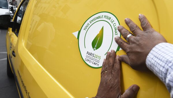 A man puts a sticker of the COP21 on a van of the French postal service, La Poste, on October 30, 2015 in Paris, ahead of the Climate Change Conference 2015. The COP21, organized by the French government will run from November 30 to December 11, 2015 - Sputnik International