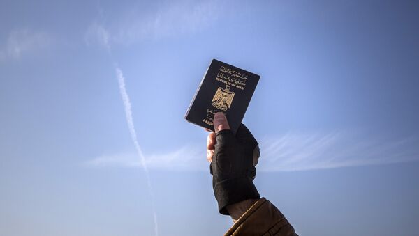 A refugee holds up his Iraqi passport at the port of Molyvos after a rescue operation by members of the Frontex, European Border Protection Agency, from Portugal near the northeastern Greek island of Lesbos, Tuesday, Dec. 8, 2015. - Sputnik International