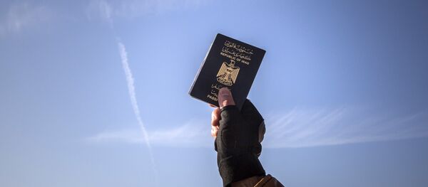 A refugee holds up his Iraqi passport at the port of Molyvos after a rescue operation by members of the Frontex, European Border Protection Agency, from Portugal near the northeastern Greek island of Lesbos, Tuesday, Dec. 8, 2015. - Sputnik International