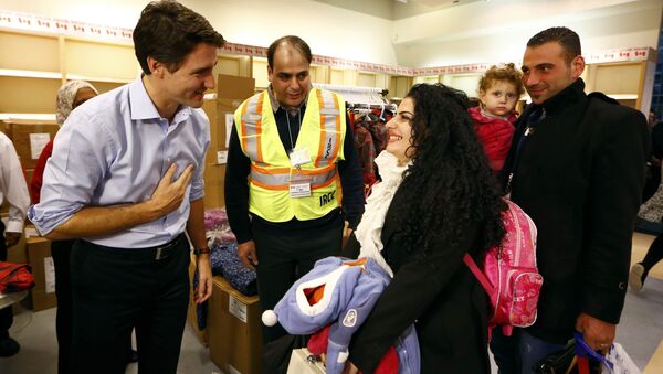 Syrian refugees are greeted by Canada's Prime Minister Justin Trudeau (L) on their arrival from Beirut at the Toronto Pearson International Airport in Mississauga, Ontario, Canada December 11, 2015 - Sputnik International
