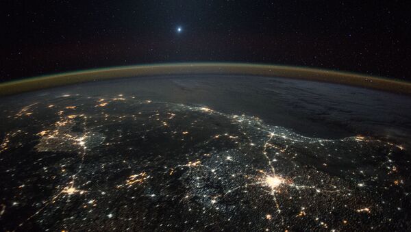 Снимок Венеры на фоне ночных огней Земли, полученное с Международной космической станции - Sputnik International