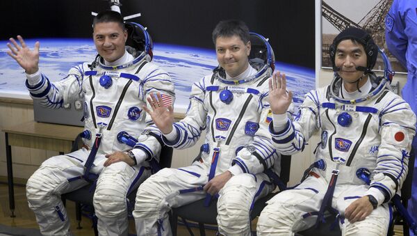 (From L) The Soyuz TMA-17M spacecraft International Space Station (ISS) crew of US astronaut Kjell Lindgren, Russian cosmonaut Oleg Kononenko and Japanese astronaut Kimiya Yui wave during a space suit testing before leaving for a launch pad of the Russian-leased Baikonur cosmodrome in Kazakhstan on July 22, 2015 a few hours before a blast off - Sputnik International