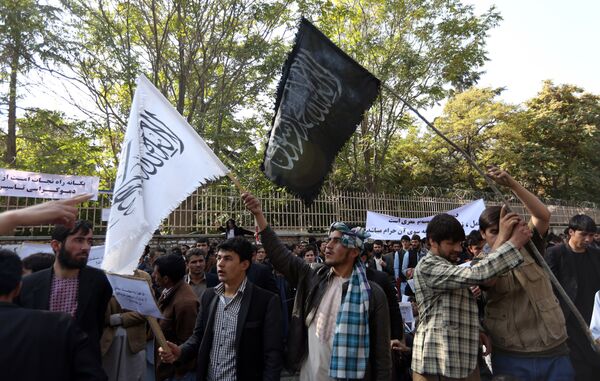 In this Saturday, Oct. 25, 2014 photo, Afghan university students wave a black flag used by the Islamic State group and a white flag used by Taliban during its 1996-2001 rule of Afghanistan at a demonstration in Kabul, Afghanistan - Sputnik International