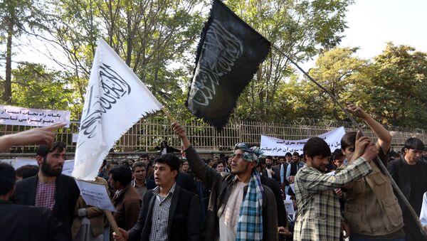 In this Saturday, Oct. 25, 2014 photo, Afghan university students wave a black flag used by the Islamic State group and a white flag used by Taliban during its 1996-2001 rule of Afghanistan at a demonstration in Kabul, Afghanistan - Sputnik International