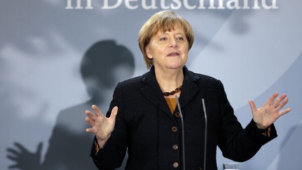 German Chancellor Angela Merkel delivers a speech during a reception at the chancellery in Berlin, Germany, Monday, Dec. 7, 2015 to mark the 60th. anniversary of the arrival of the first migrant workers in Germany. Slogan reads 'in Germany'. - Sputnik International