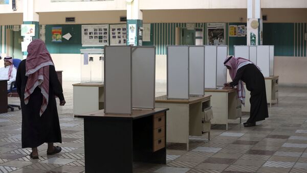 A Saudi man, right, prepares to cast his vote at a polling center during the country's municipal elections in Riyadh, Saudi Arabia, Saturday, Dec. 12, 2015 - Sputnik International