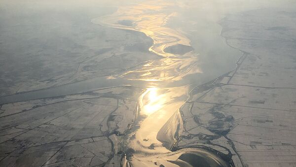 In this Friday, Nov. 27, 2015, photo, which was taken from an airplane approaching Pyongyang, light from the evening sun is cast on a river flowing through snow covered farm fields in North Korea - Sputnik International