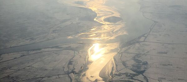 In this Friday, Nov. 27, 2015, photo, which was taken from an airplane approaching Pyongyang, light from the evening sun is cast on a river flowing through snow covered farm fields in North Korea In this Friday, Nov. 27, 2015, photo, which was taken from an airplane approaching Pyongyang, light from the evening sun is cast on a river flowing through snow covered farm fields in North Korea - Sputnik International