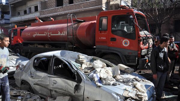 A firefighter truck is seen next to a destroyed car at the site of a car bomb explosion in al-Zahra neighborhood in Homs - Sputnik International