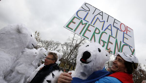 Jean-Baptiste Redde aka Voltuan holds a banner reading State of climate emergency next to demonstrators dressed-up as polar bears during a rally called by several Non Governmental Organisations (NGO) to form a human chain on the Champs de Mars near the Eiffel Tower in Paris on December 12, 2015 on the sidelines of the COP21, the UN conference on global warming. - Sputnik International