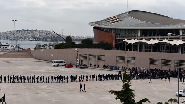 Migrants and refugees line up for food outside of a temporary housing facility for migrants located in a former Olympic hall in Faliro suburb of Athens on December 11, 2015. - Sputnik International