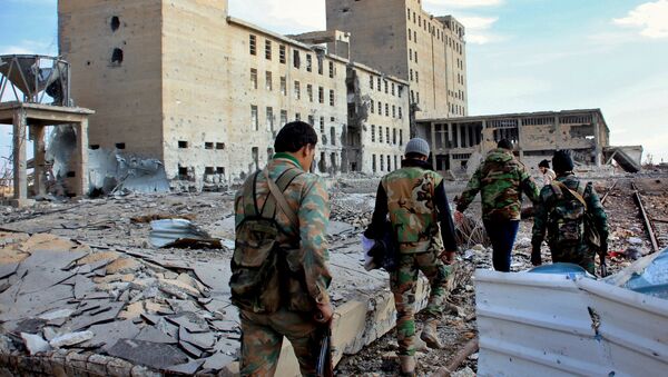 Syrian army soldiers patrol near a building previously used for storing seeds in the countryside of Deir Hafer, a former bastion of Islamic State group, near the northern Syrian city of Aleppo on December 2, 2015 - Sputnik International