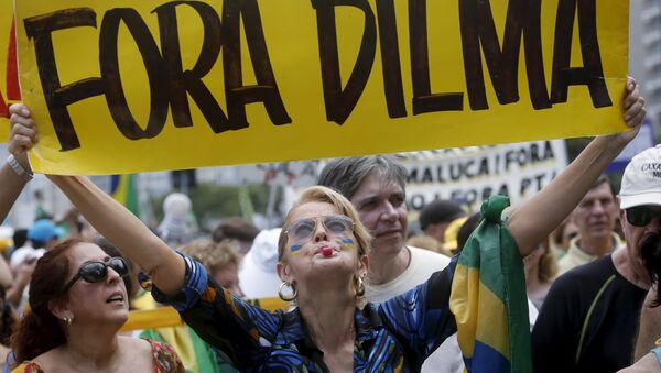 A demonstrator holds a banner which reads Out Dilma during a protest calling for the impeachment of Brazil's President Dilma Rousseff in Rio de Janeiro - Sputnik International