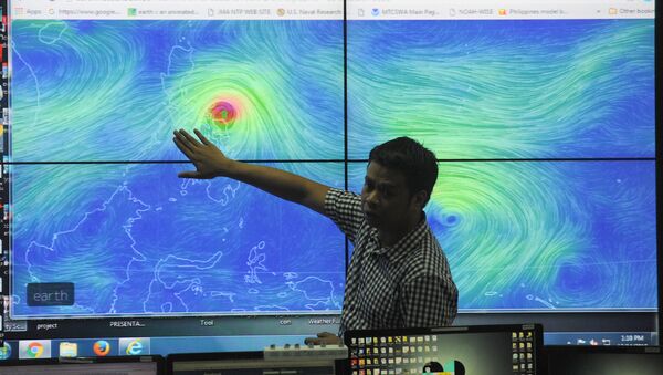 Meteorologists from the Philippine Atmospheric Geophysical and Astronomical Services Administration (PAGASA) monitor and plot the direction of powerful Typhoon Melor at their headquarters in suburban Manila on December 14, 2015. - Sputnik International