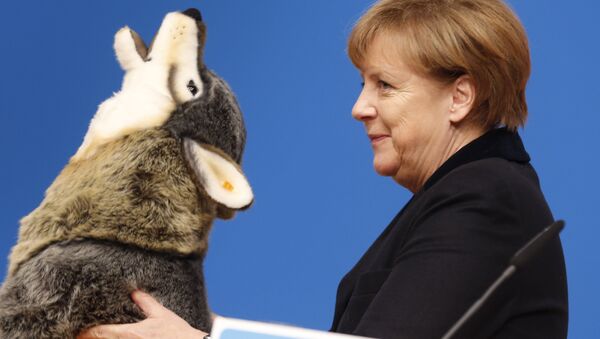 German Chancellor Angela Merkel holds a toy wolf she got as a present during a party convention of the Christian Democrats (CDU) in Karlsruhe, Germany, Monday, Dec. 14, 2015. - Sputnik International