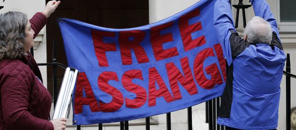 Protestors hang a banner opposite the Ecuadorian Embassy, in London, Monday, Dec. 14, 2015. - Sputnik International