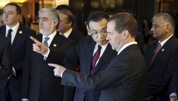 Chinese Premier Li Keqiang (C) talks to his Russian counterpart Dmitry Medvedev (front) as they visit an exhibition, ahead of the 14th Shanghai Cooperation Organization (SCO) Prime Ministers' Meeting, in Zhengzhou, Henan province, China, December 14, 2015 - Sputnik International