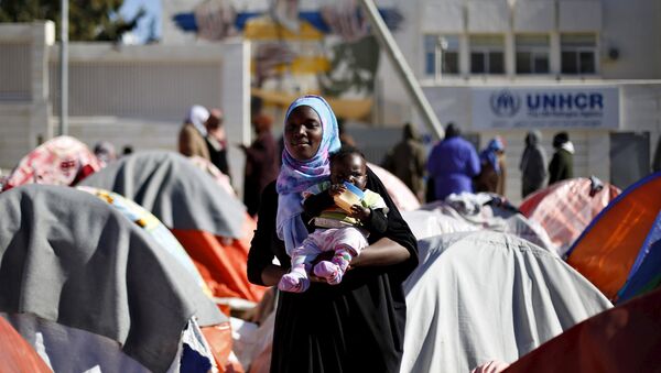 A Sudanese refugee from Darfur carries her child during an open-ended sit-in outside the United Nations High Commissioner for Refugees (UNHCR), demanding better treatment and acceleration of their relocation, in Amman, Jordan, December 6, 2015. - Sputnik International