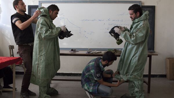 Aleppo University student, shows Syrian citizens hows to put protective gear as he instructs them with rudimentary means of how to respond to a chemical attack, in the northern Syrian city of Aleppo. file photo - Sputnik International