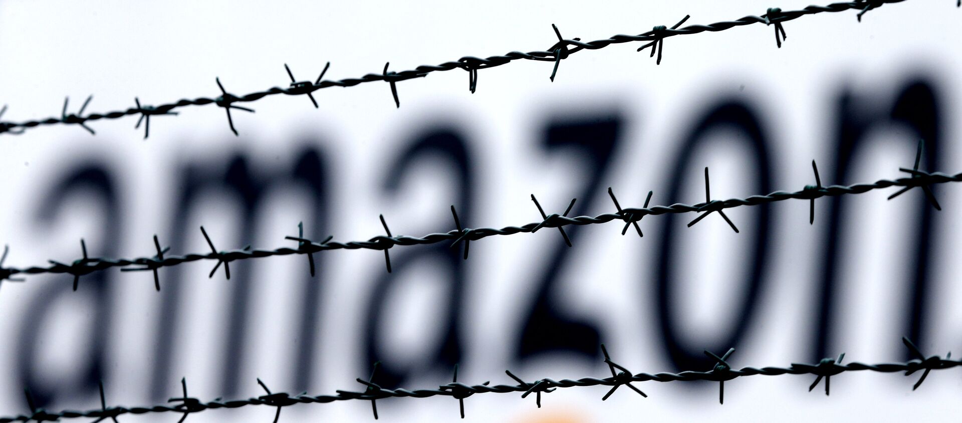 The internet trader Amazon logo is seen behind barbed wire at the company's logistics centre in Rheinberg, Germany, 19 February 2013. - Sputnik International, 1920, 18.02.2021