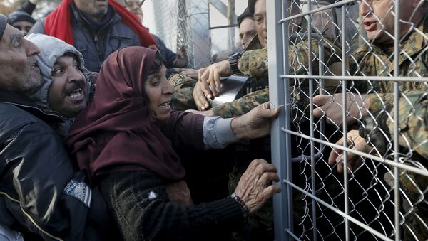 Syrian refugees struggle to enter Macedonia through a narrow border crossing as Macedonian policemen try to shut a metal gate near to the Greek village of Idomeni December 4, 2015 - Sputnik International