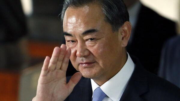 Chinese Foreign Minster Wang Yi waves to the media as he leaves the Department of Foreign Affairs - Sputnik International