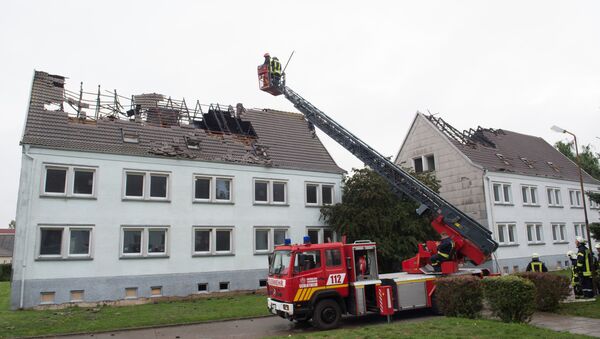 Firefighters look at a house that was meant to shelter migrants in Ebeleben, eastern Germany, Monday Sept. 7, 2015 - Sputnik International