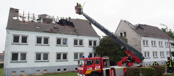 Firefighters look at a house that was meant to shelter migrants in Ebeleben, eastern Germany, Monday Sept. 7, 2015 Firefighters look at a house that was meant to shelter migrants in Ebeleben, eastern Germany, Monday Sept. 7, 2015 - Sputnik International