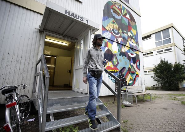 Mohamed Shmer, 24, a refugee from Syria, leaves house 1 at a camp for refugees and migrants in Berlin, Germany, Friday, Sept. 11, 2015 - Sputnik International